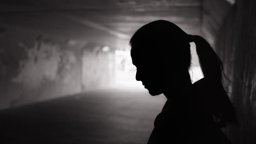 Ilustrasi wanita sedih Depressed sad young female standing in a dark tunnel