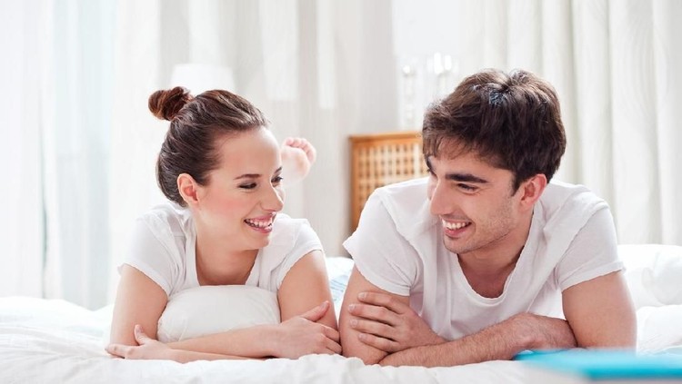 Happy couple celebrating Christmas in bed