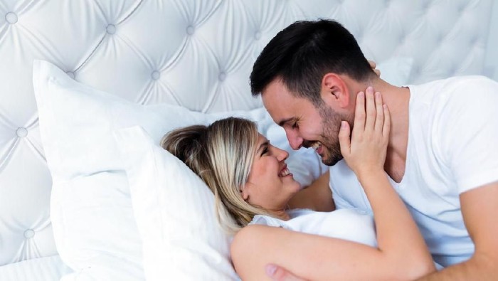 Happy couple celebrating Christmas in bed