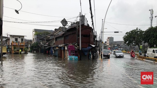 Genangan air dipicu luapan dari Sungai Ciliwung yang berada di sisi jalan. Air merembes ke sejumlah saluran pembuangan air dan luber ke Jalan Jatinegara Barat.