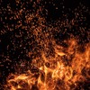 Burning sparks flying. Beautiful flames. Fiery orange glowing flying away particles on black background.