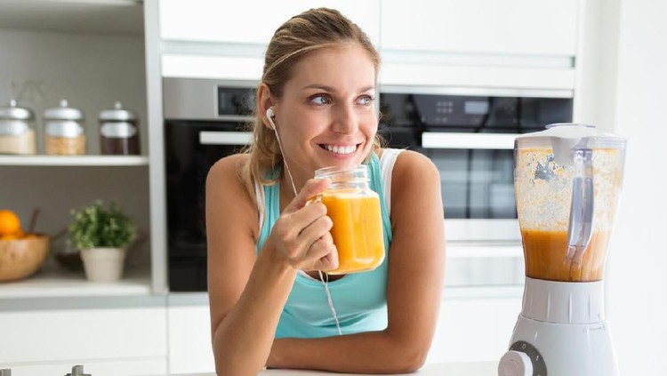 Shot of beautiful sporty young woman looking sideways and drinking vegetable detox juice in the kitchen at home.