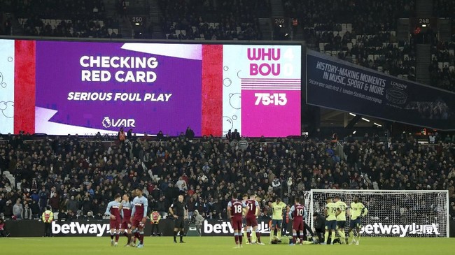 VAR checks a red card decision before over ruling a red card given to West Ham United's Aaron Cresswell, during the game against Bournemouth, during their English Premier League soccer match at the London Stadium, in London, Wednesday Jan. 1, 2020. (Bradley Collyer/PA via AP)