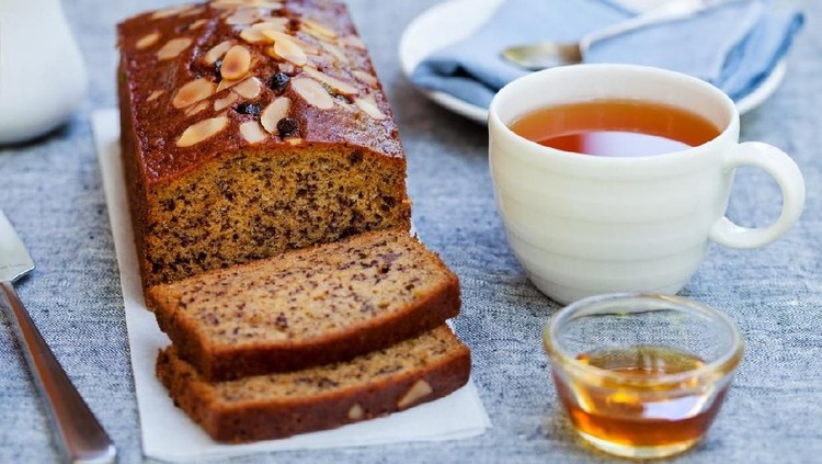 Banana, carrot, apple cake, loaf with chocolate and cup of tea on grey background