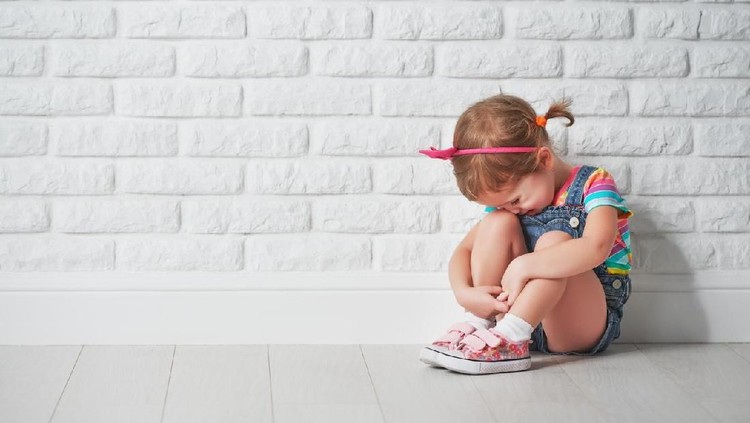 little child girl crying and sad about an empty brick wall