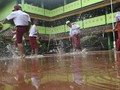 FOTO: Tak Gentar Hadapi Banjir di Hari Pertama Sekolah
