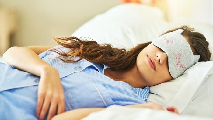Cropped shot of an attractive young woman wearing a sleep mask while lying in bed