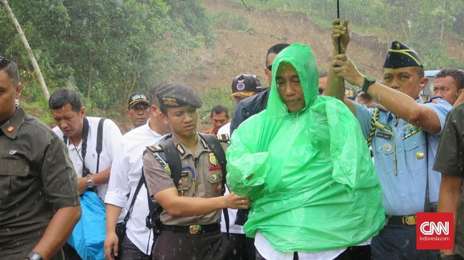 Jokowi terpaksa kembali ke kantor desa saat hendak ke titik longsor longsor di Kecamatan Sukajaya, Bogor karena tiba-tiba turun hujan deras.