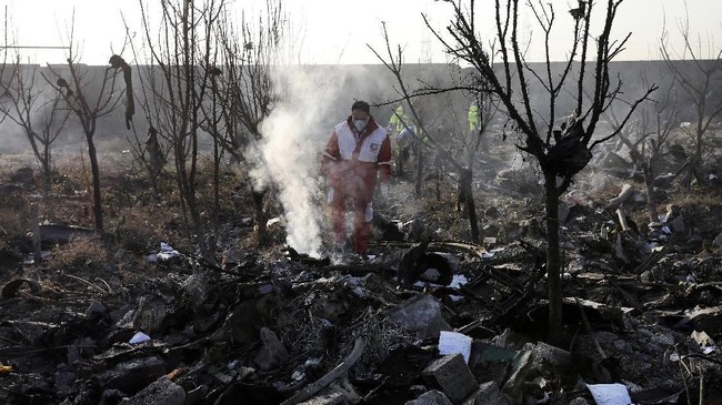 Rescue workers search the scene where an Ukrainian plane crashed in Shahedshahr, southwest of the capital Tehran, Iran, Wednesday, Jan. 8, 2020. A Ukrainian airplane carrying 176 people crashed on Wednesday shortly after takeoff from Tehran's main airport, killing all onboard. (AP Photo/Ebrahim Noroozi)