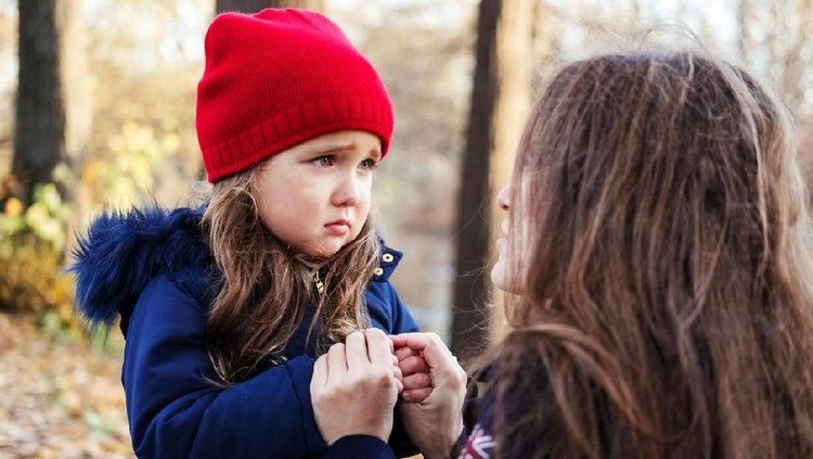 anak cemas Scared daughter holding mother's hands in autumn park. Child girl express sad emotions, complain about their own problems