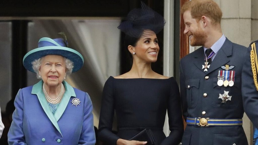FILE - In this Tuesday, July 10, 2018 file photo Britain's Queen Elizabeth II, and Meghan the Duchess of Sussex and Prince Harry watch a flypast of Royal Air Force aircraft pass over Buckingham Palace in London. In a stunning declaration, Britain's Prince Harry and his wife, Meghan, said they are planning 