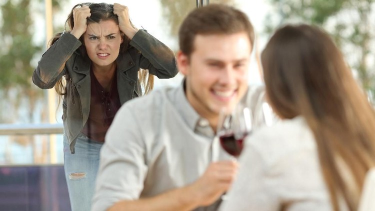 Couple lying in bed while someone is watching in front of the door