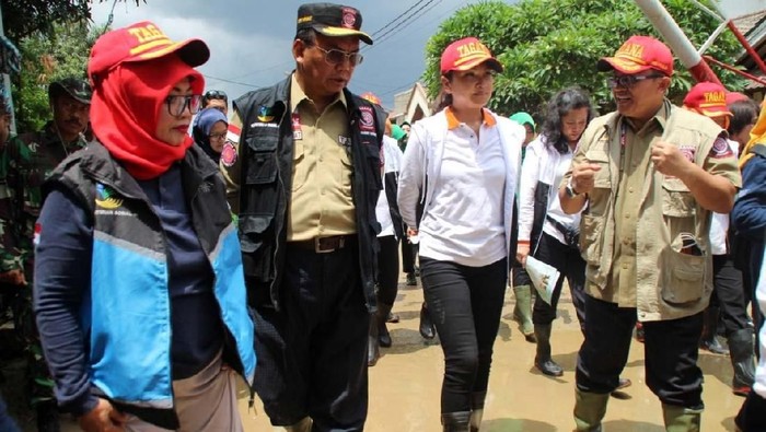 Istri menteri sosial Grace Claudia Pieters Batubara mengunjungi korban banjir di Villa Nusa Indah 2, Bogor, Jawa Barat, Minggu (12/1). Ia menyerahkan bantuan alat kebersihan.