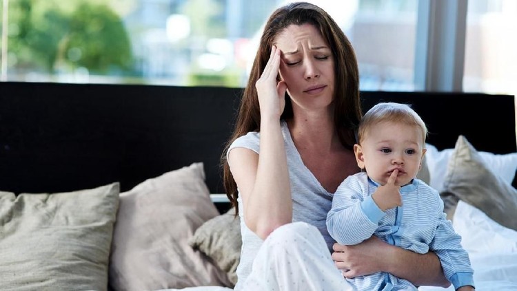 Concept of motherhood, multi-tasking and family. Mother of two children having headache