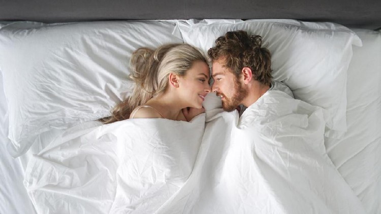 Couple is hugging and taking selfie on the bed in the morning