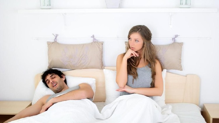 Young couple lying in bed, woman in foreground, portrait