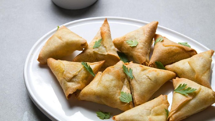 Plate vegetarian samosas on gray background