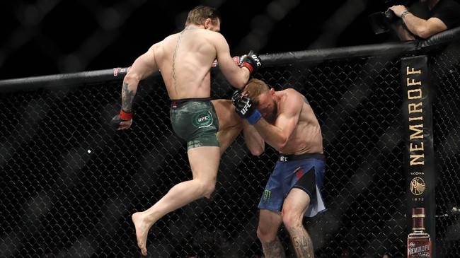 Melihat 'Cowboy' Cerrone kehilangan kestabilan, McGregor lantas memanfaatkan kesempatan dengan melakukan serangan lanjutan dengan menghantamkan dengkul ke muka lawan. (Steve Marcus/Getty Images/AFP)