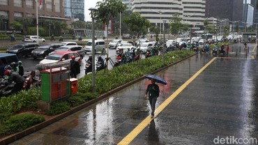 Berteduh Saat Hujan Harus Tetap Jaga Jarak