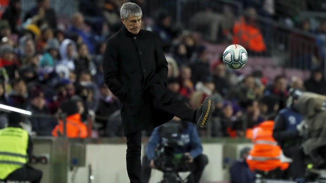 Barcelona's head coach Quique Setien kicks the ball back to the pitch during a Spanish La Liga soccer match between Barcelona and Granada at Camp Nou stadium in Barcelona, Spain, Sunday, Jan. 19, 2020. (AP Photo/Joan Monfort)