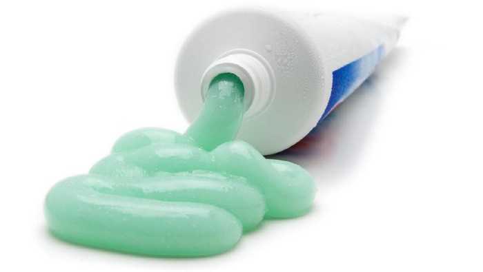 Toothpaste cascades from the tube.