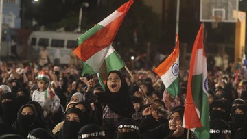 An Indian Muslim girl ties an Indian flag as she participates in a protest against a new citizenship law that opponents say threatens India's secular identity, in Mumbai, India, Tuesday, Jan. 28, 2020. The new citizenship law and a proposed National Register of Citizens have brought thousands of protesters out in the streets in many cities and towns since Parliament approved the measure on Dec. 11. (AP Photo/Rafiq Maqbool)