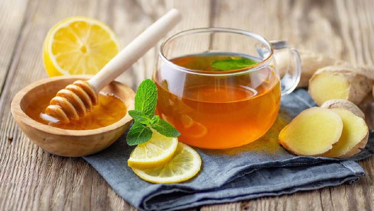 1142669969 A glass cup of tea with lemon, mint, ginger and honey on wooden rustic table.