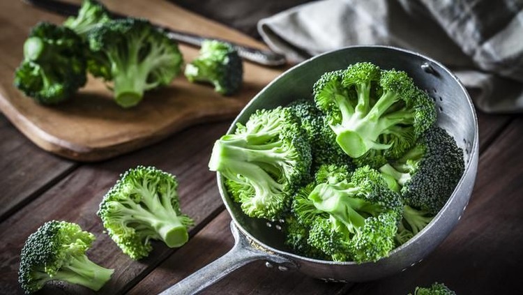 Fresh organic broccoli in an old metal colander shot on rustic wooden table. This vegetable is considered a healthy salad ingredient. Predominant colors are green and brown. Low key DSRL studio photo taken with Canon EOS 5D Mk II and Canon EF 100mm f/2.8L Macro IS USM