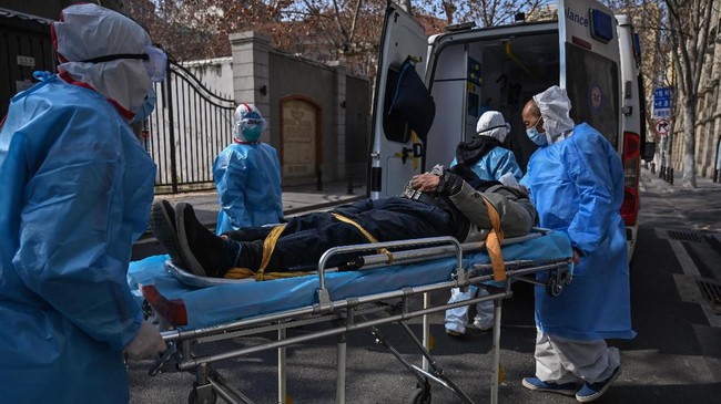Medical staff in protective clothes are seen carrying a patient from an apartment suspected of having the virus in Wuhan, in Hubei province on January 30, 2020. - The World Health Organization, which initially downplayed the severity of a disease that has now killed 170 nationwide, warned all governments to be "on alert" as it weighed whether to declare a global health emergency. (Photo by Hector RETAMAL / AFP)