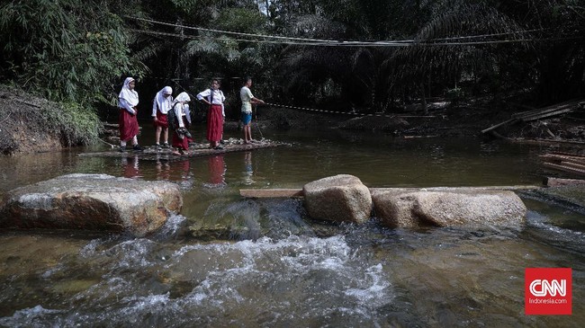Murid-murid pulang mengunakan rakit usai belajar di SDN 10/Sekolah Marjinal yang terletak di Dusun Sialang Harapan Desa Batu Sasak, Kecamatan Kampar Kampar Kiri, Kabupaten Kampar, Riau, 16 Desember 2019. Sekolah ini sudah tidak terlalu memprihatinkan karena telah mengalami renovasi, namun tidak bisa dibandingkan dengan sekolah di perkotaan. CNNIndonesia/Safir Makki