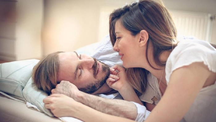 I love spending time with you. Young happy couple in bed. Space for copy. Cloe up.