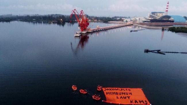 Warga Bengkulu membentangkan spanduk protes soal PLTU batu bara bersamaan dengan kedatangan Jokowi ke provinsi tersebut.
