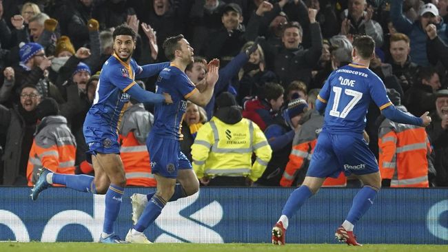 Shrewsbury Town's Shaun Whalley, center, is congratulated by teammates after scoring a goal that was disallowed in a VAR decision during the English FA Cup Fourth Round replay soccer match between Liverpool and Shrewsbury Town at Anfield Stadium, Liverpool, England, Tuesday, Feb. 4, 2020. (AP Photo/Jon Super)