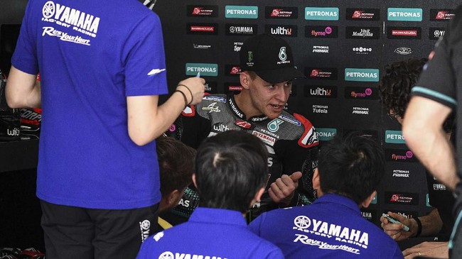 Petronas Yamaha SRT's French rider Fabio Quartararo (C) speaks with team members during the first day of the pre-season MotoGP winter test at the Sepang International Circuit in Sepang on February 7, 2020. (Photo by Mohd RASFAN / AFP)