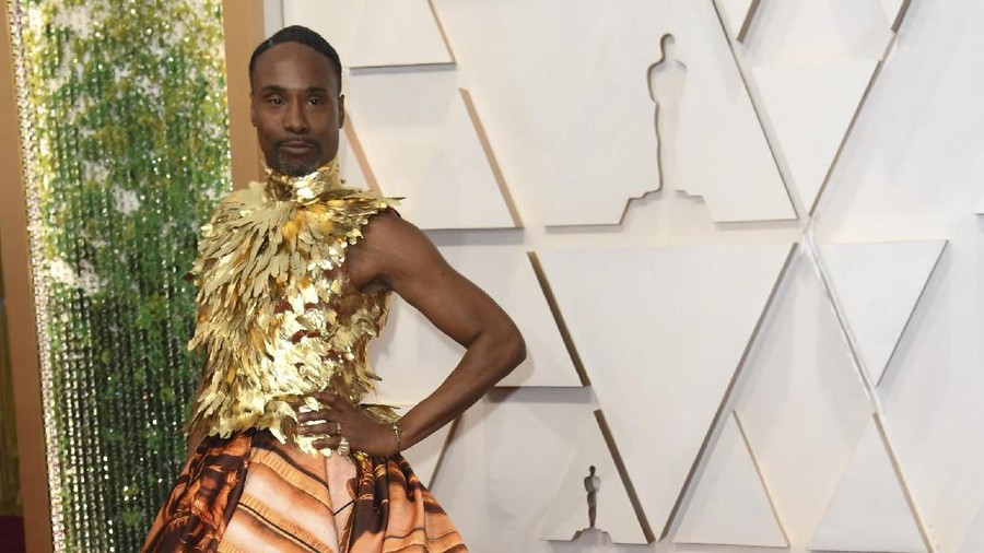 Penampilan Billy Porter terinspirasi dari Kerajaan Inggris. Billy tampil dengan gaun korset leher berwarna emas dengan rok grafis.