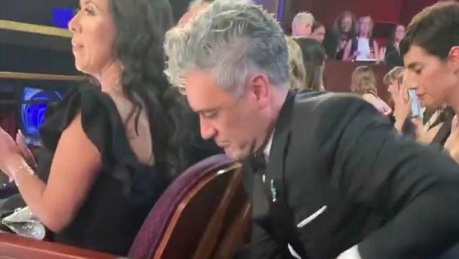 Aksi kocak sutradara Jojo Rabbit, Taika Waititi, yang menaruh piala Oscar di kolong kursi tamu yang berada di depannya jadi sorotan.