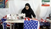 FOTO : Menuai Untung dari Membakar Bendera AS-Israel Sebuah pabrik di Iran menuai keuntungan dengan membuat replika bendera AS dan Israel untuk dibakar.