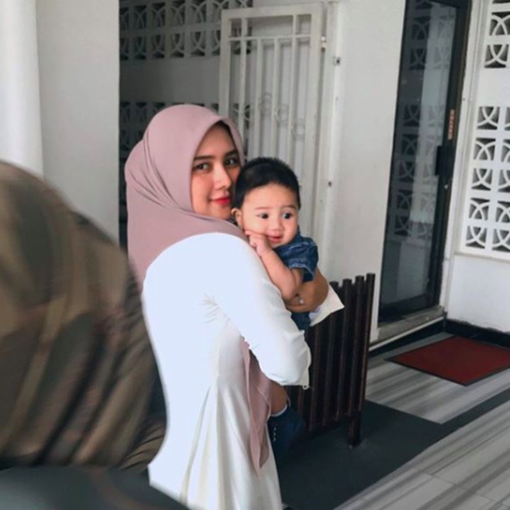<p>Una saat menggendong seorang bayi. Sudah terlihat keibuannya ya. (Foto: Instagram @unamaulina)</p>