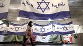 FOTO : Menuai Untung dari Membakar Bendera AS-Israel Sebuah pabrik di Iran menuai keuntungan dengan membuat replika bendera AS dan Israel untuk dibakar.
