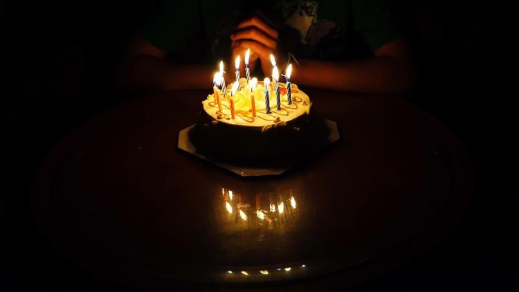 The boy is requesting blessings on his birthday by having a cake.