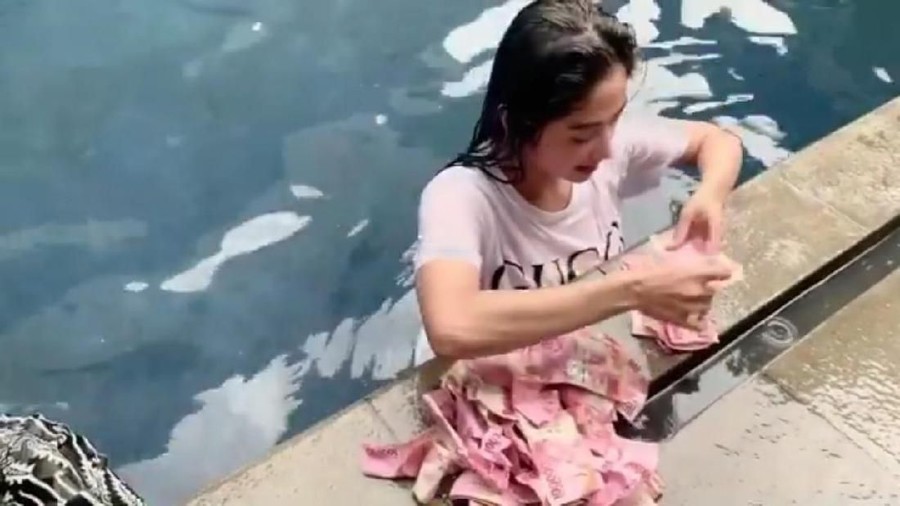 Dewi Perssik menebar uang jutaan rupiah di kolam renang untuk para pegawainya.