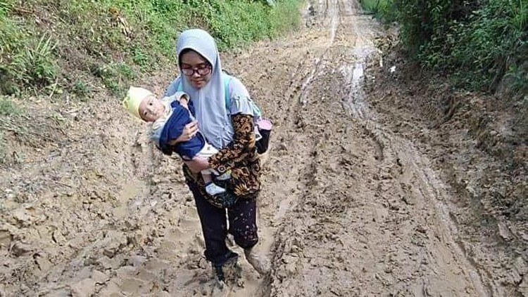 Seorang guru perempuan menjadi viral setelah menggendong anaknya sambil menerjang lumpur dan menaiki bukit untuk sampai ke sekolah.