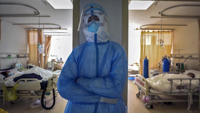 In this Sunday, Feb. 16, 2020, photo, a medical worker takes a nap at a hospital in Wuhan in central China's Hubei province. Chinese authorities on Monday reported a slight upturn in new virus cases and hundred more deaths for a total of thousands since the outbreak began two months ago. (Chinatopix via AP)