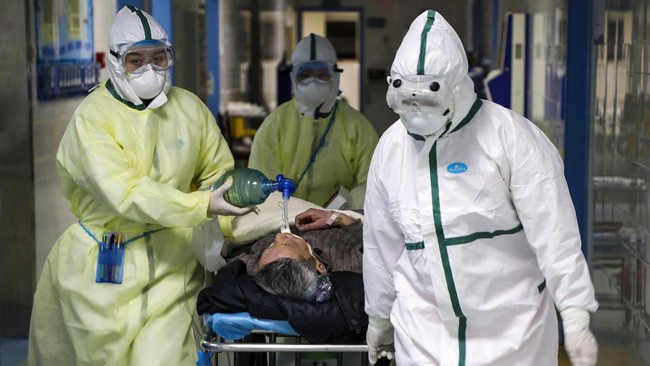 In this Thursday, Feb. 6, 2020, photo, medical workers transfer a patient in the isolation ward for 2019-nCoV patients at a hospital in Wuhan in central China's Hubei province. The number of confirmed cases of the new virus has risen again in China on Saturday, Feb. 8, 2020, as the ruling Communist Party faced anger and recriminations from the public over the death of a doctor who was threatened by police after trying to sound the alarm about the disease over a month ago. (Chinatopix via AP)