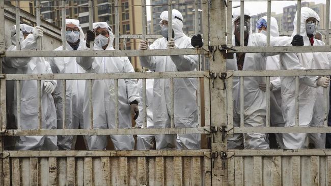 In this Thursday, Feb. 6, 2020, photo, workers in protective suits ride on a truck carrying medical supplies into Huoshenshan temporary hospital built for patients who diagnosed with 2019-nCoV in Wuhan in central China's Hubei province. The number of confirmed cases of the new virus has risen again in China on Saturday as the ruling Communist Party faced anger and recriminations from the public over the death of a doctor who was threatened by police after trying to sound the alarm about the disease over a month ago. (Chinatopix via AP)