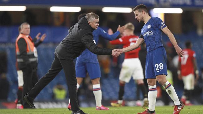 Manchester United's manager Ole Gunnar Solskjaer, left, shakes the hand of Chelsea's Cesar Azpilicueta after their English Premier League soccer match at Stamford Bridge in London, England, Monday, Feb. 17, 2020. (AP Photo/Ian Walton)
