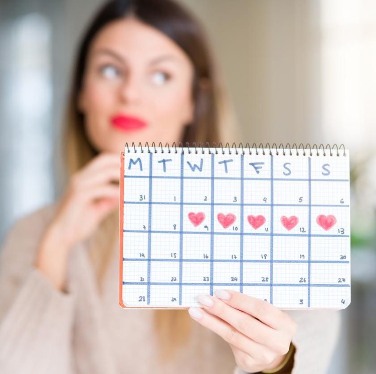 Menghitung masa subur Young beautiful woman holding menstruation calendar at home serious face thinking about question, very confused idea