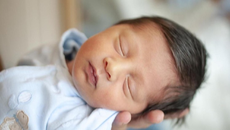 nama bayi Turkish newborn sleeping in his mother's arm