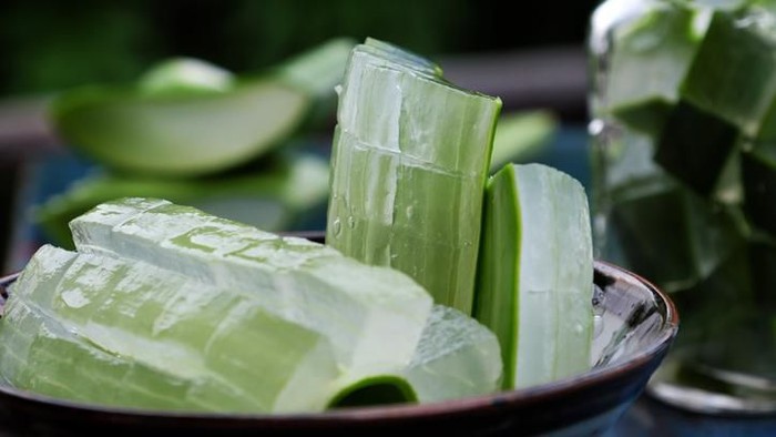 Healthy Aloe vera juice in a mason jar glass. Top view scene on a wooden paddle board.