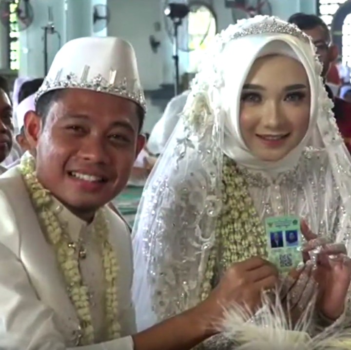 Usai ijab kabul, Evan Dimas dan Zahra Hakim berfoto pamerkan buku nikah dan kartu nikah. (Foto: YouTube Mahar Agung Organizer)